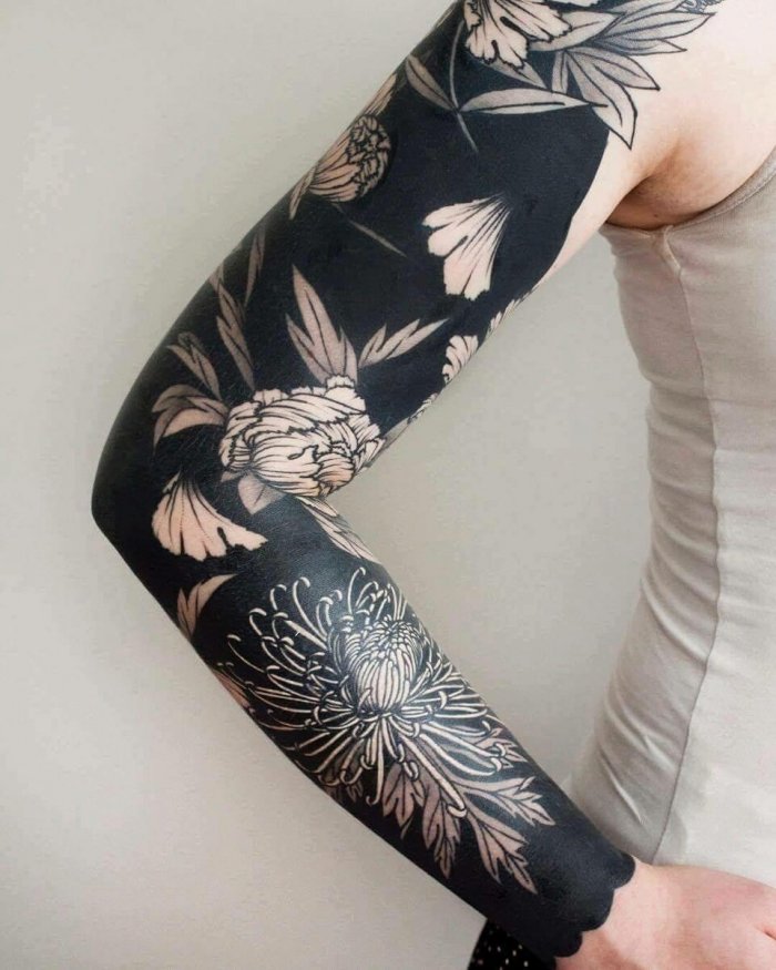 Blackwork style tattoo on the arm for women