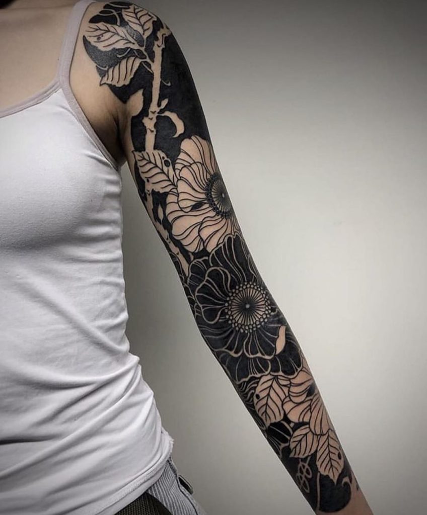 Blackwork style tattoo on the arm for women