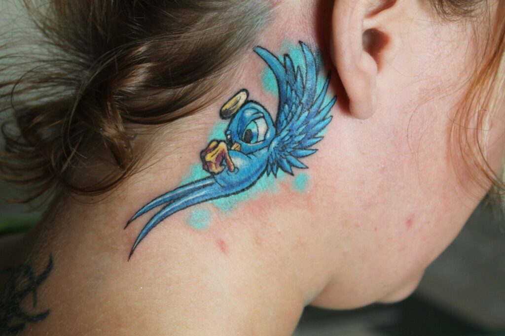 Colorful bird tattoo on the neck for women