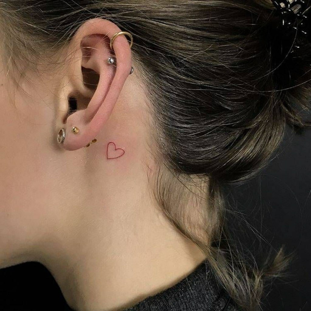 A small heart tattoo on the neck for women