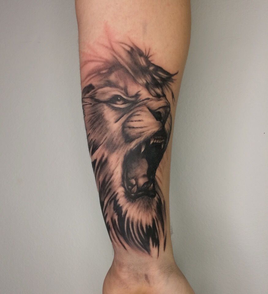 A lion tattoo on the forearm for men