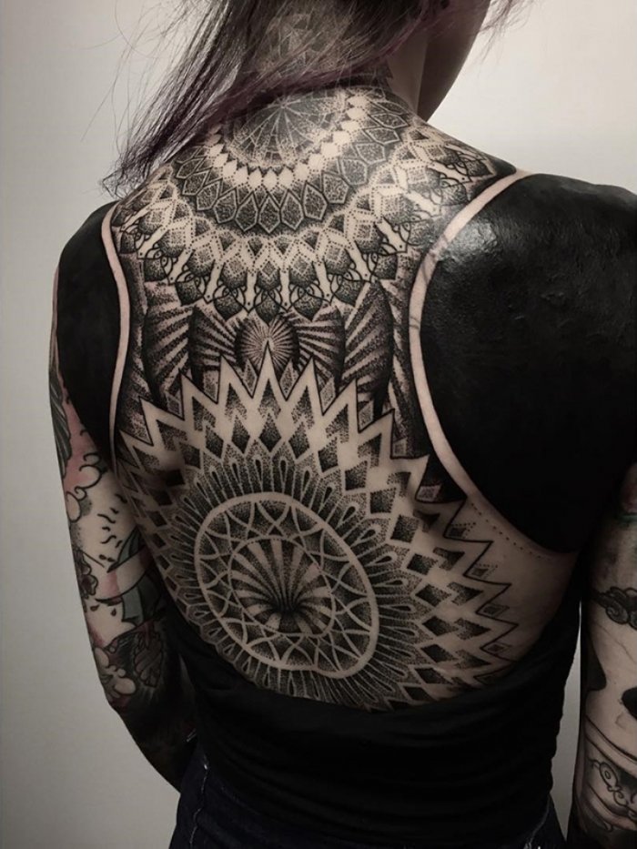 Large blackwork style tattoo on the back for women