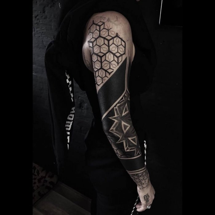 Large blackwork tattoo on the arm for men