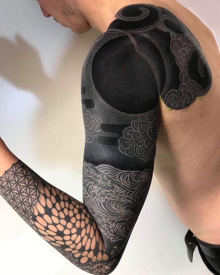 Large blackwork tattoo on the arm for men