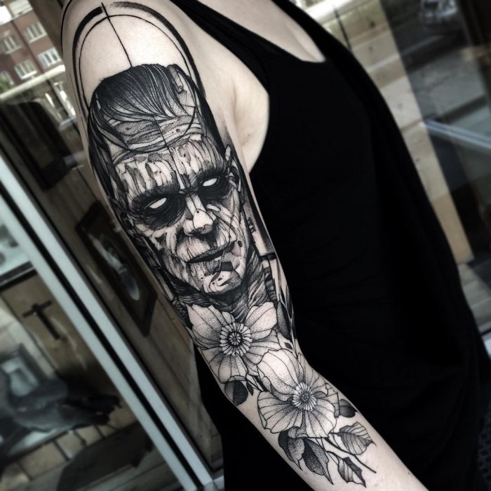 Large blackwork style tattoo on the arm for men