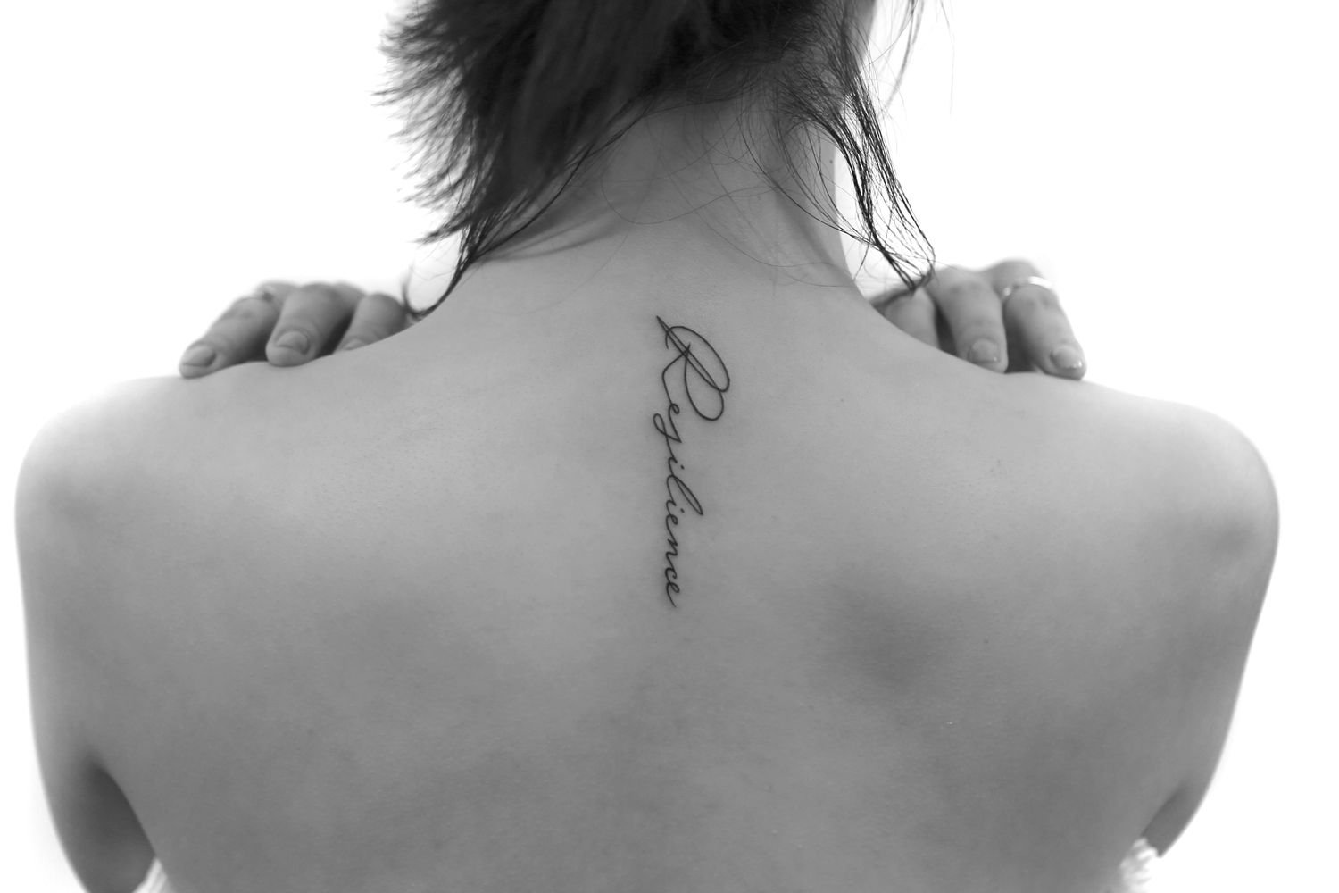 Tattoo with an inscription on the back for women