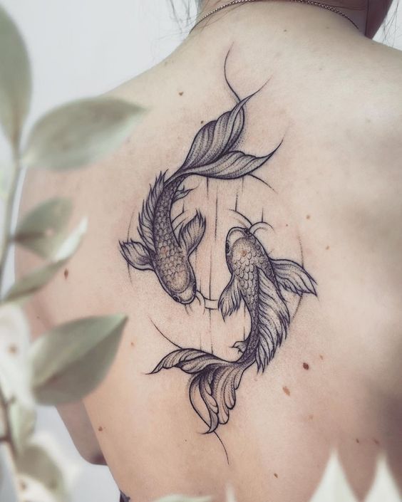 Tattoo of koi fish on the back for women