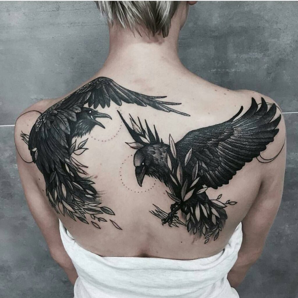 Large tattoo of two crows on the back for women