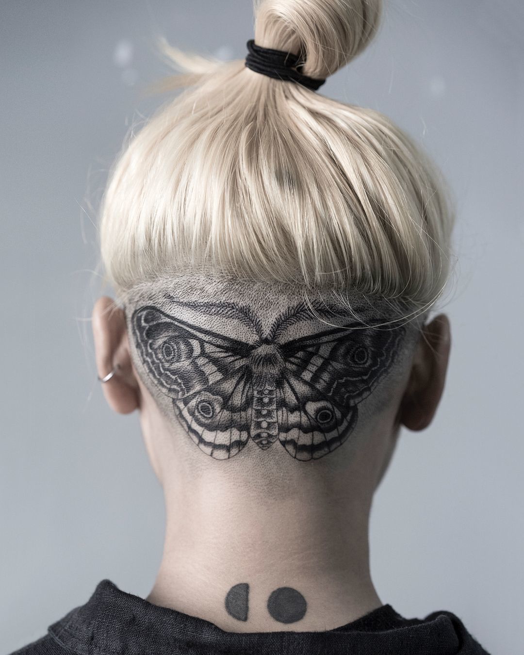 Large butterfly tattoo on the back of the head for women