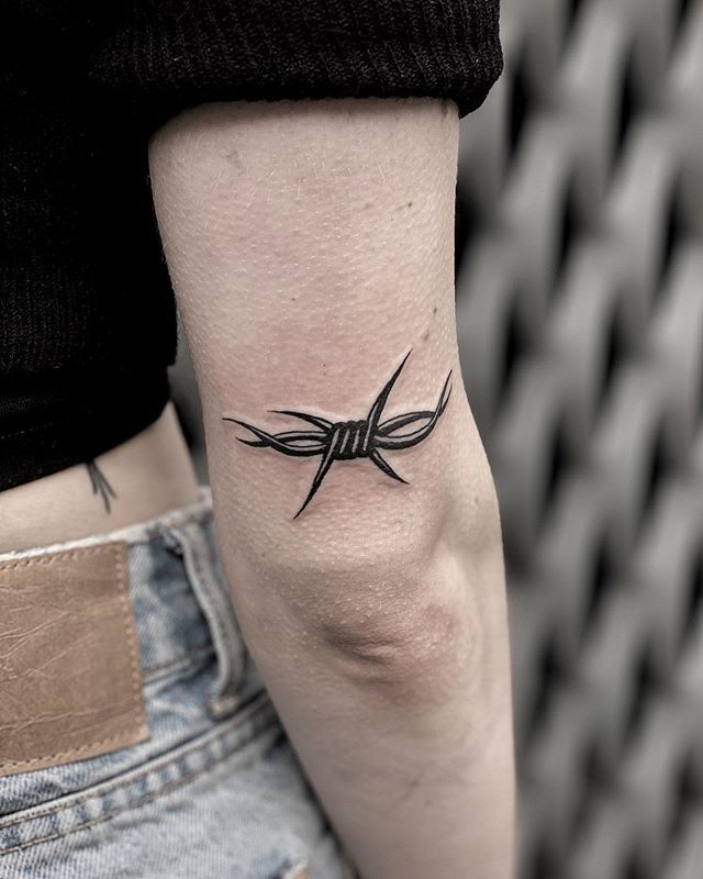 Barbed wire tattoo above the elbow for women