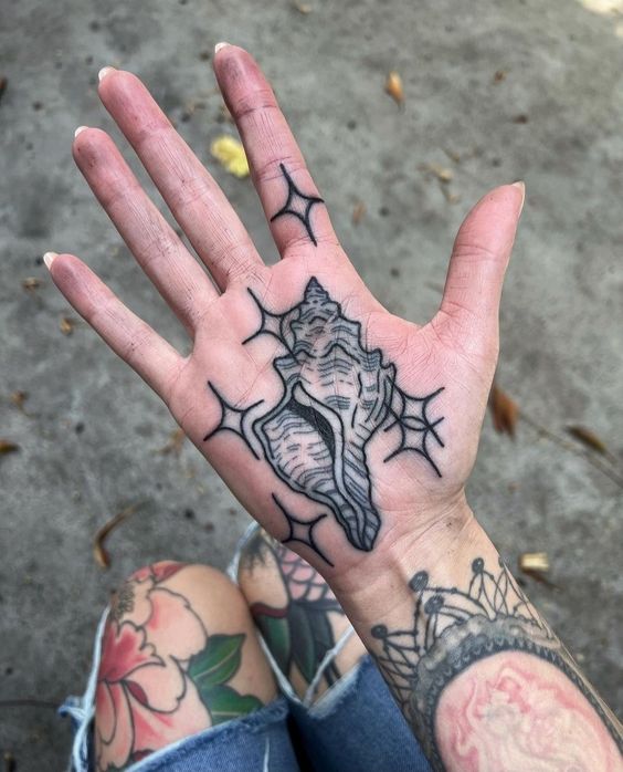 Tattoo of a seashell on the palm for women