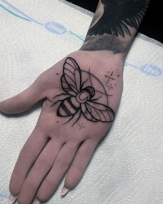 Tattoo of a bee on the palm of the hand for women