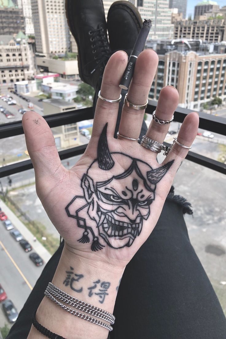 Large devil tattoo on the palm of the hand for women