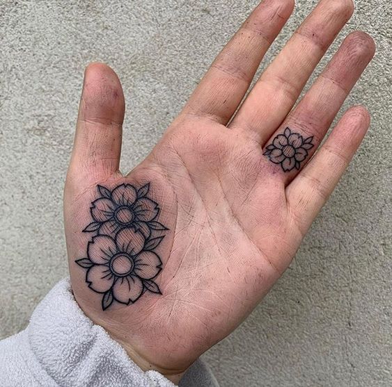 Tattoo of two flowers on the palm of the hand for women