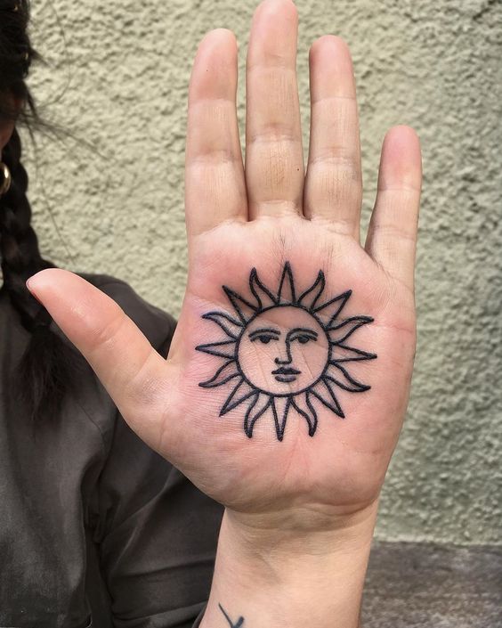 Sun tattoo on the palm of the hand for women