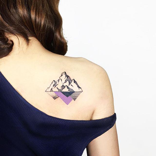 Colorful mountain tattoo on the shoulder blade for women