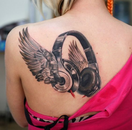 Tattoo of earbuds and crilly on the shoulder blade for women