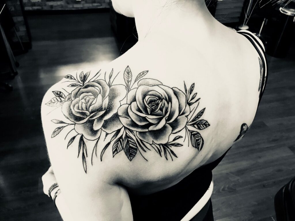 Tattoo of two roses on the shoulder blade for women