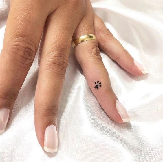 A little paw tattoo on the finger for women