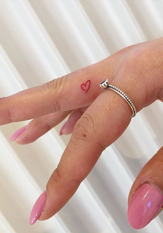 Colorful heart tattoo on the finger for women