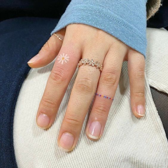 Daisy tattoo on the finger for women