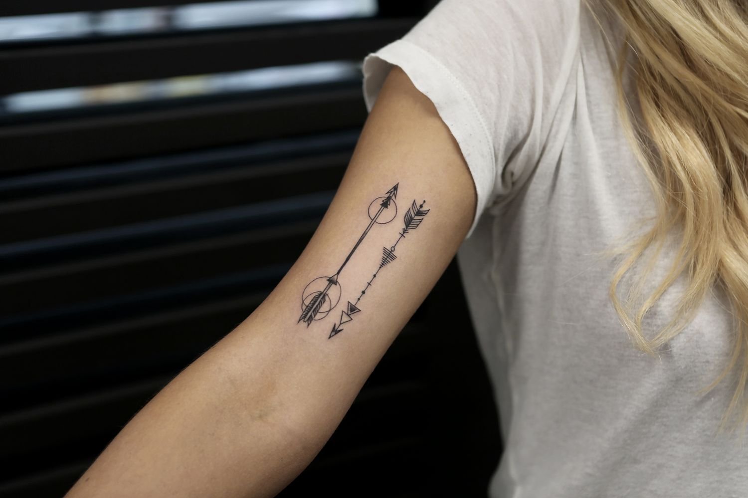 Tattoo of two arrows on the arm for women