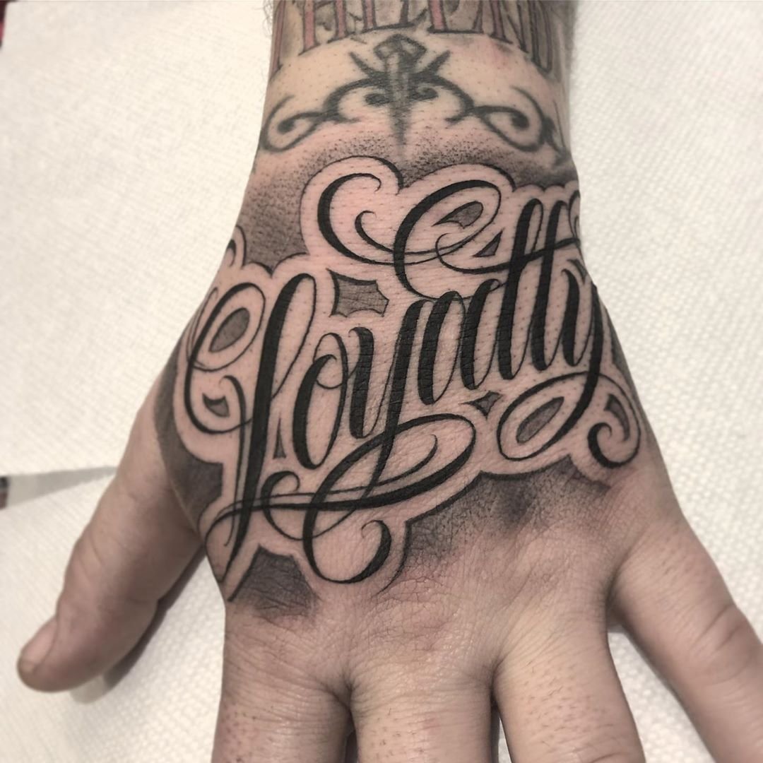 Tattoo with inscription on the hand for men