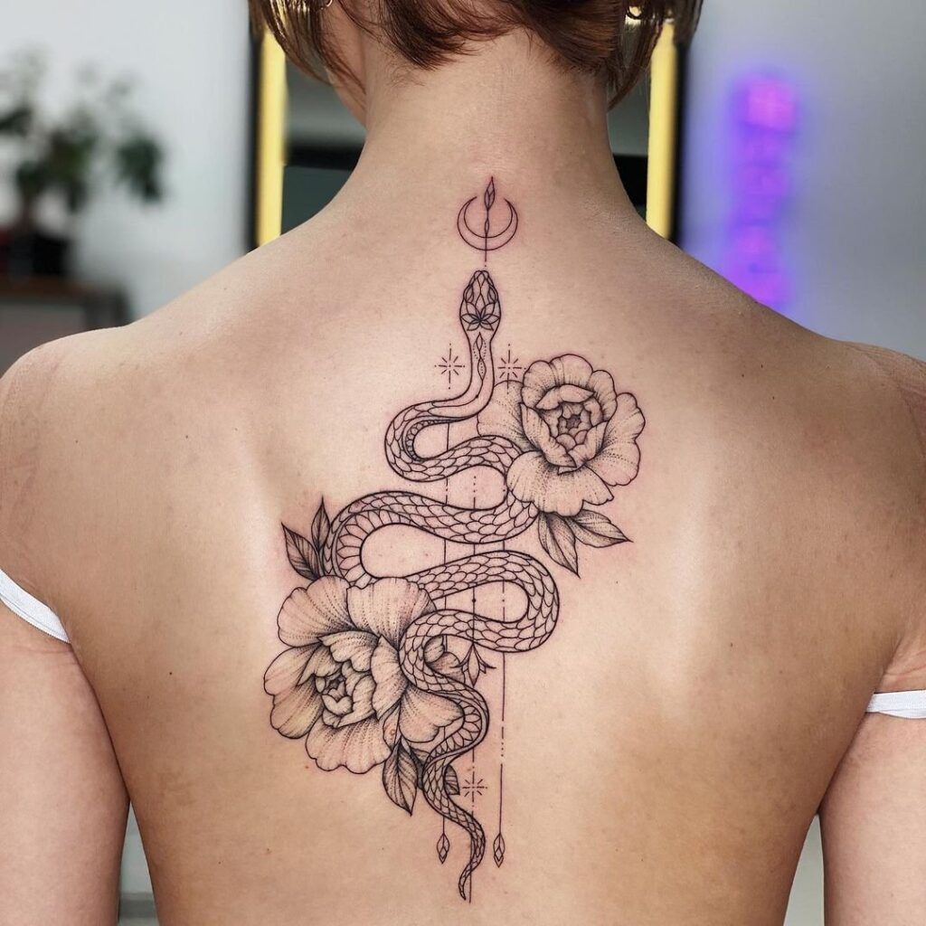 Snake and flowers tattoo on the back for women