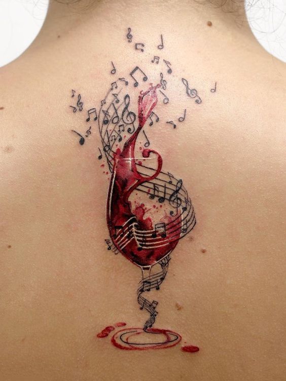 Colorful wine and sheet music tattoo on the back for women