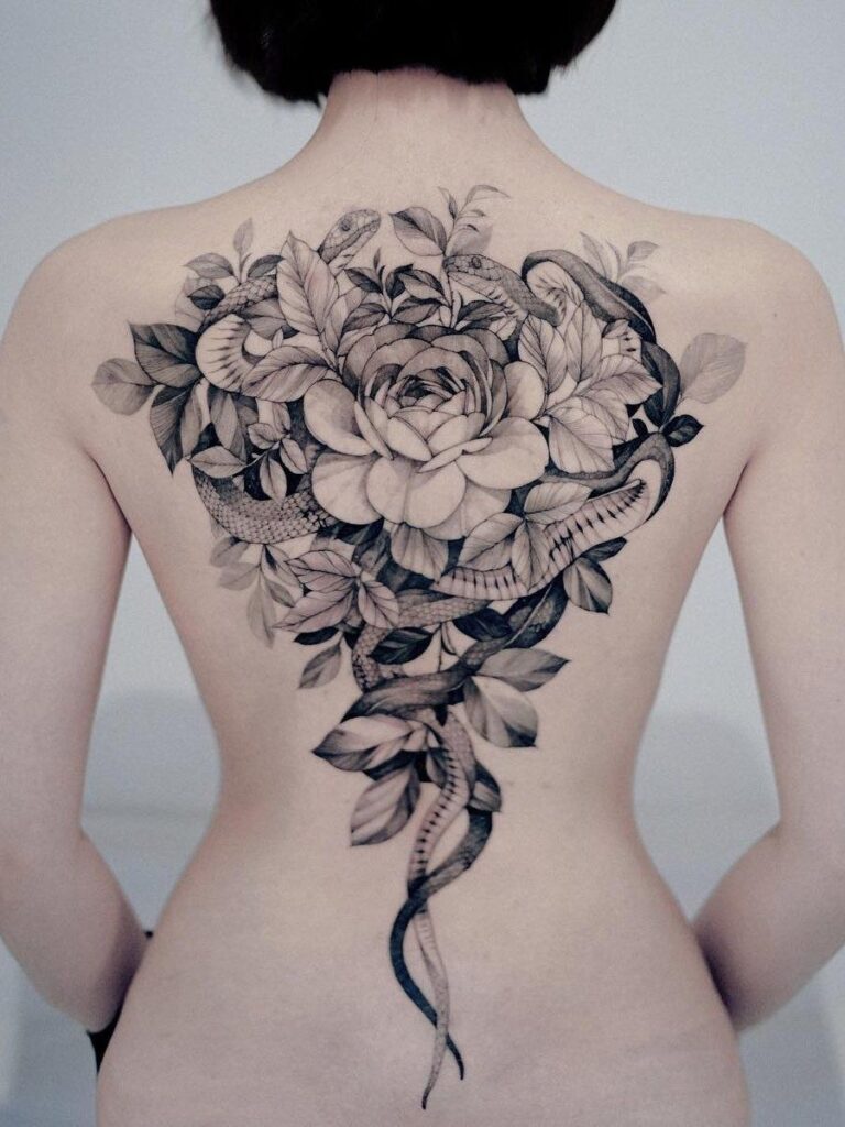 Tattoo of snakes and flowers on the back for women