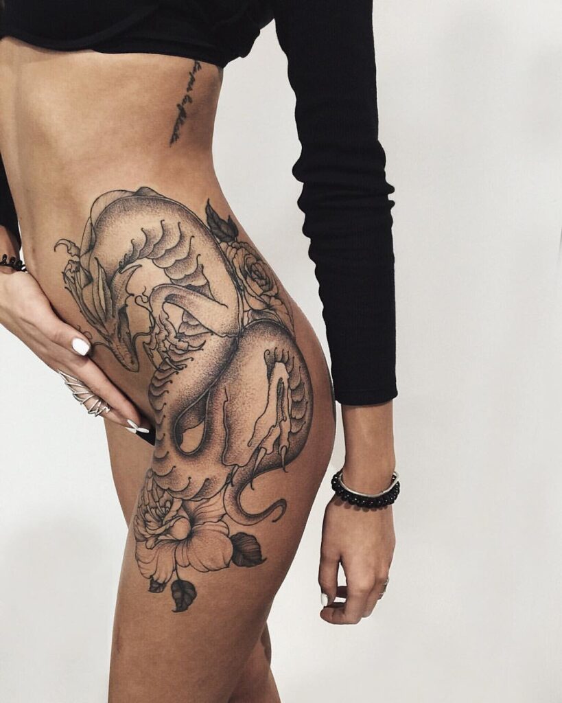 Large dragon tattoo on the thigh for women