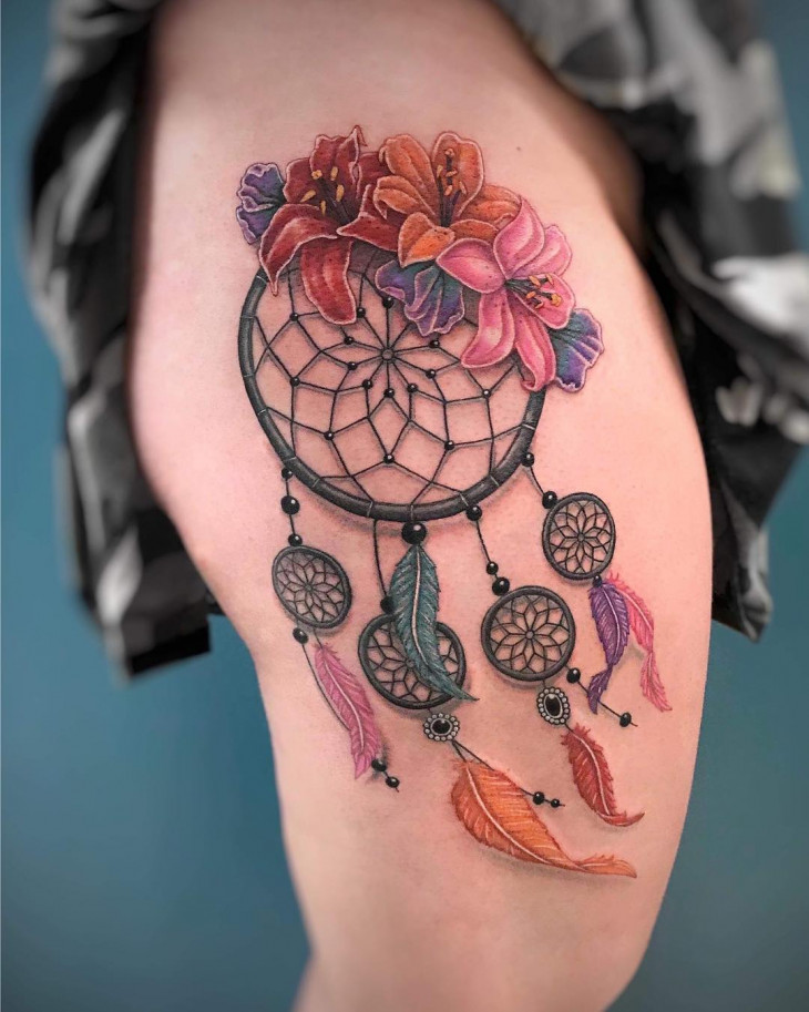 Colorful dreamcatcher and flower tattoo on the thigh for women