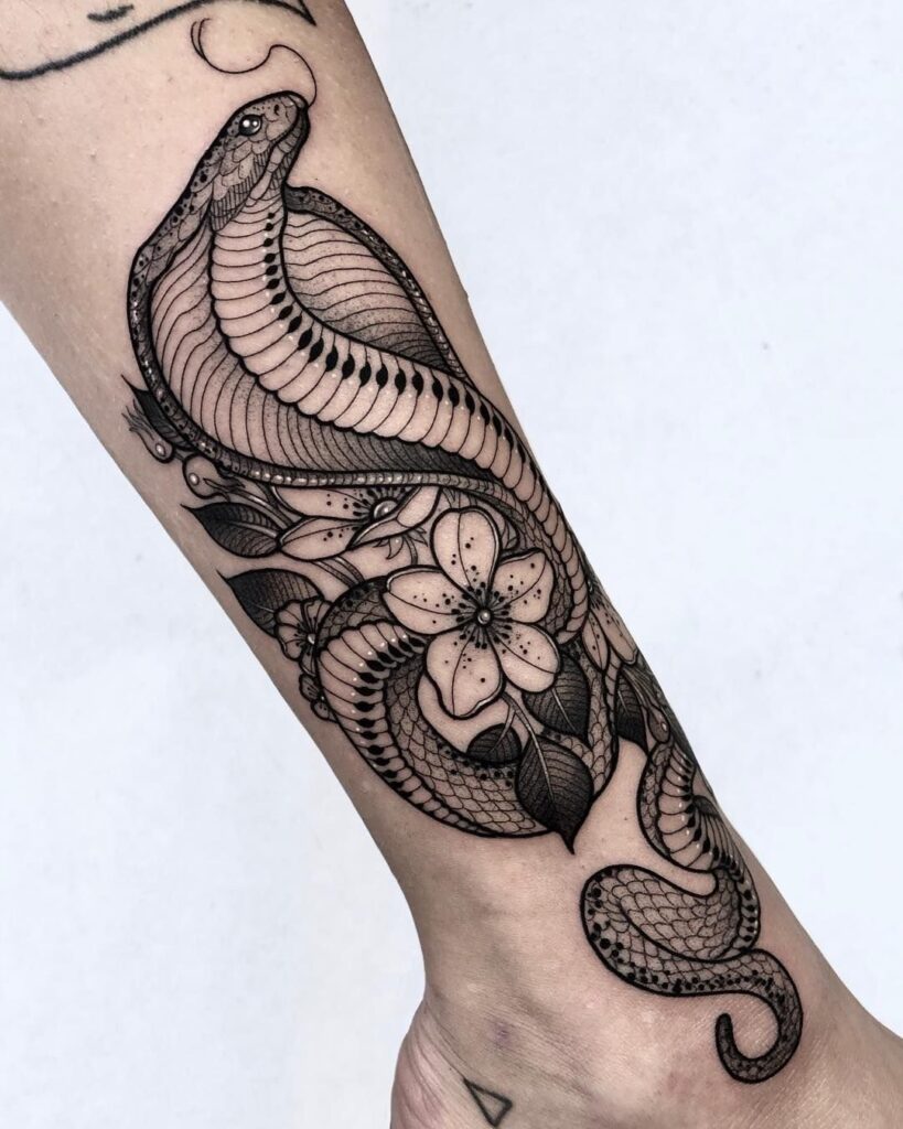 Cobra and flowers tattoo on the forearm for women