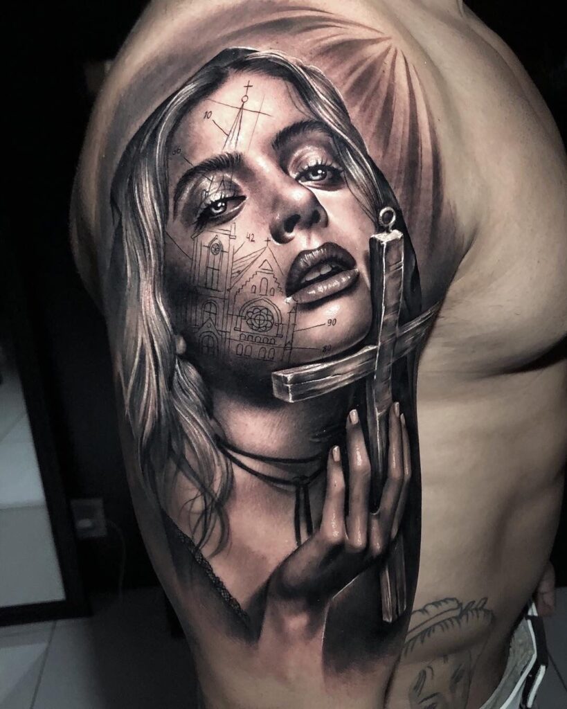 Large tattoo of a girl with a cross in black&grey style on the shoulder for men