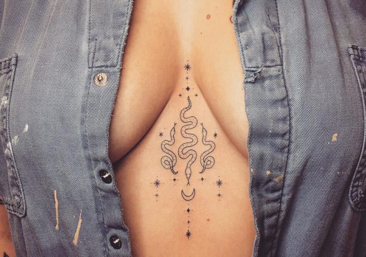 Tattoo of three snakes on the chest for women