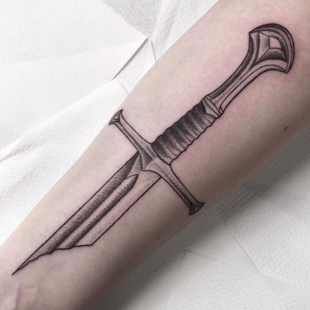 Graphic style dagger tattoo on the arm for men