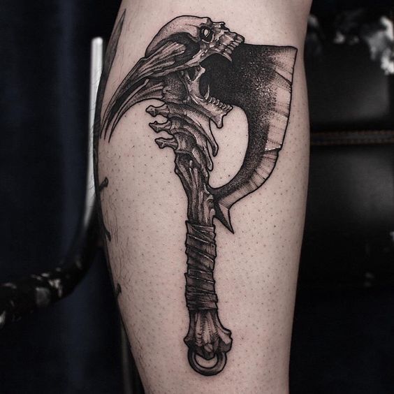 Large graphic style axe tattoo on the shin for men