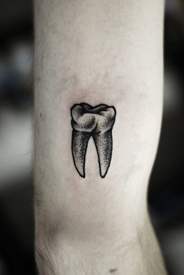 Graphic style tooth tattoo on the shoulder for men