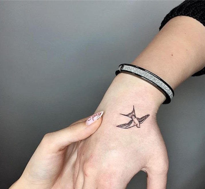 Tattoo of a swallow on the hand for women