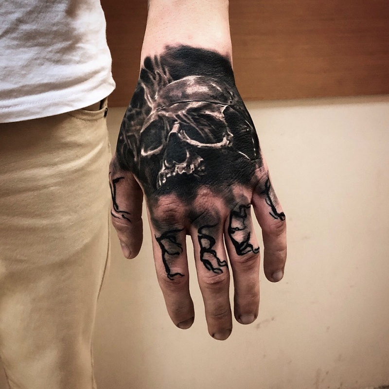 Skull tattoo on the hand for men