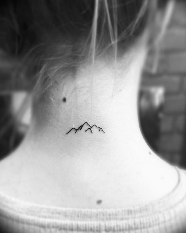 A small tattoo of mountains on the neck for women