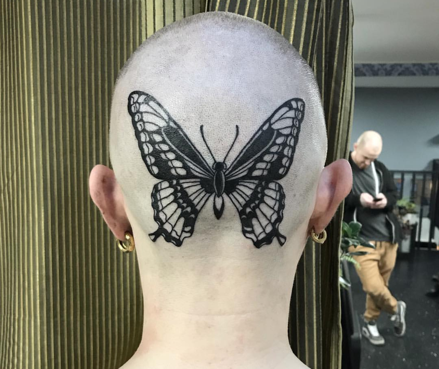 Large butterfly tattoo on the back of the head for women