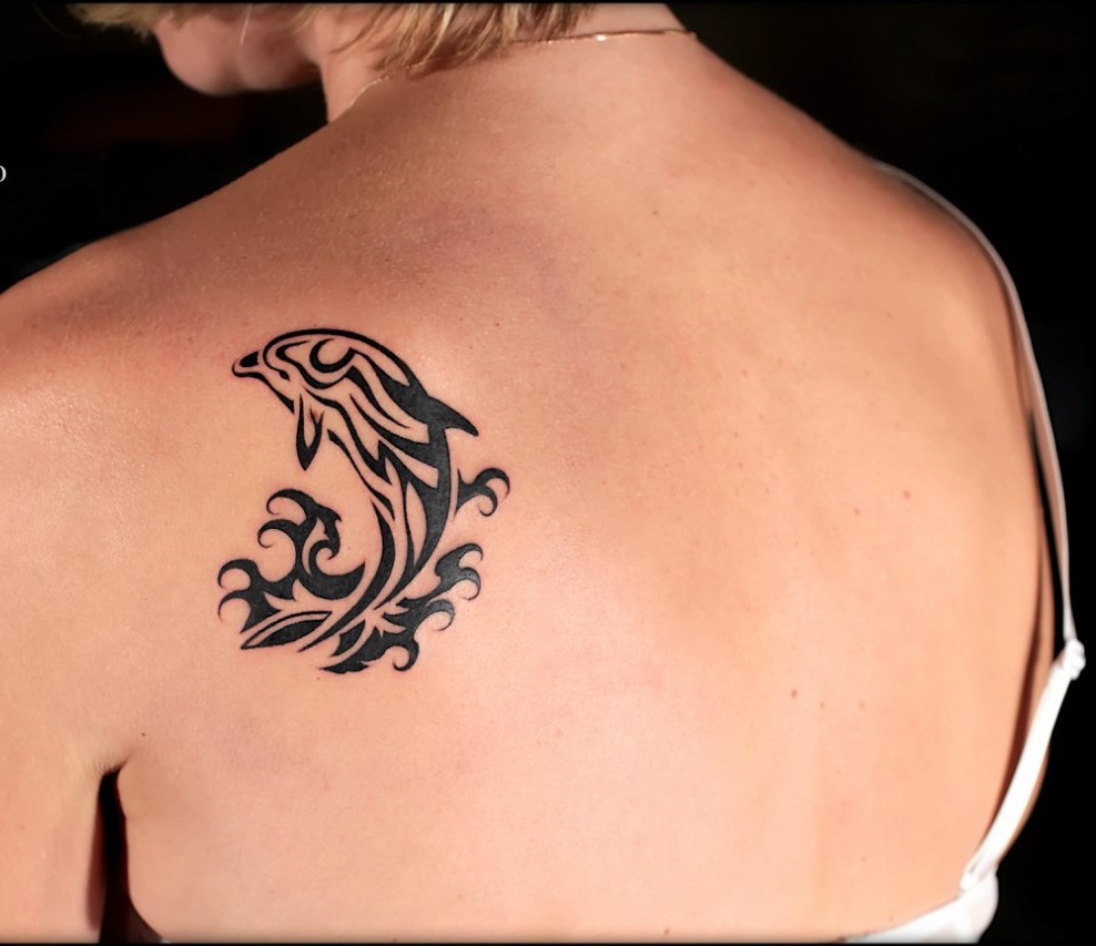 Dolphin tattoo on the shoulder blade for women