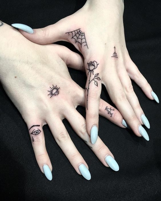 Eye and rose tattoo on fingers for women