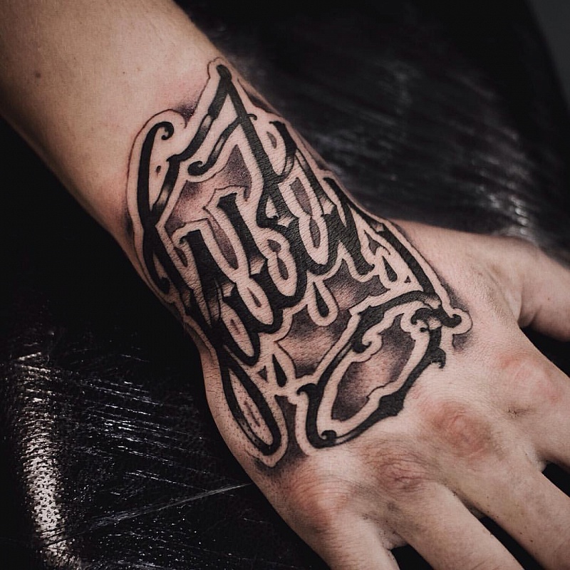 Tattoo with inscription on the hand for men