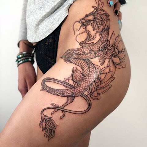 Large dragon tattoo on the thigh for women