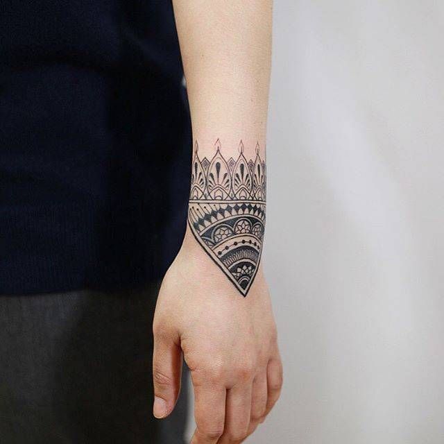 Ornamental style tattoo on the wrist for men