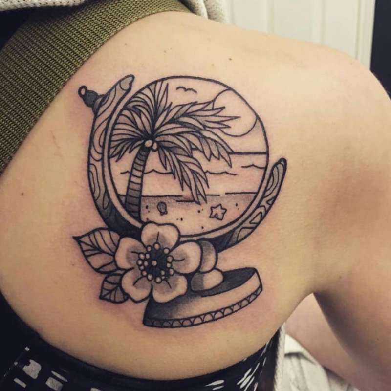 Globe tattoo on the shoulder blade for women