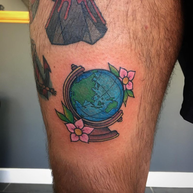 Color globe tattoo on thigh for men