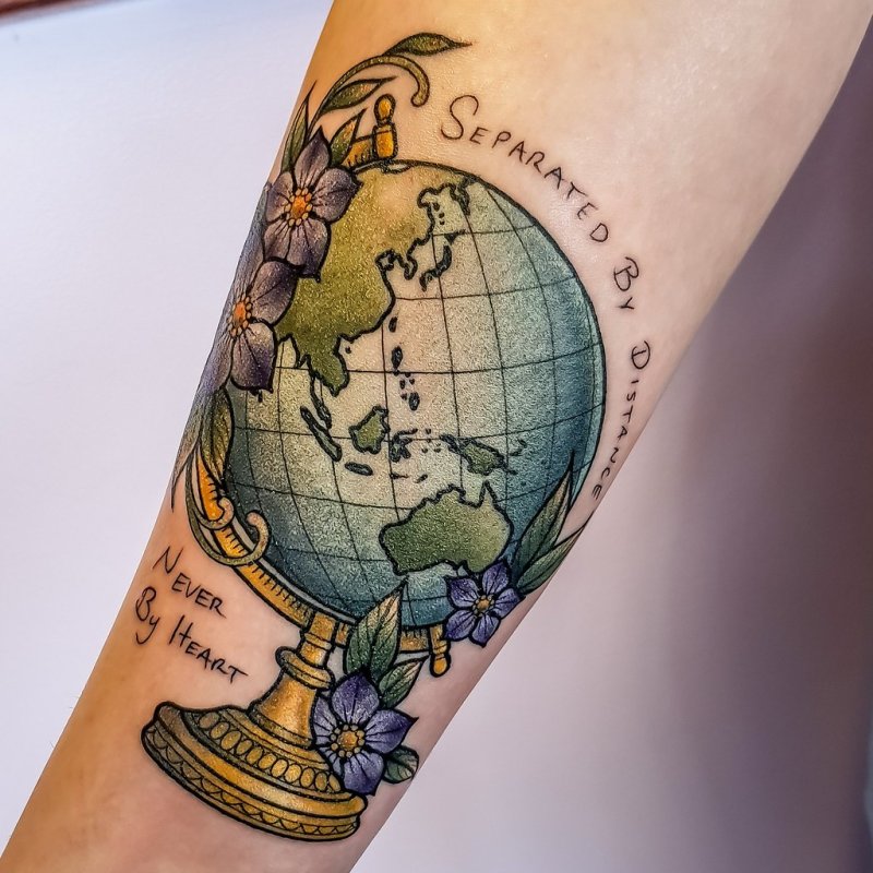 Color globe tattoo on arm for men